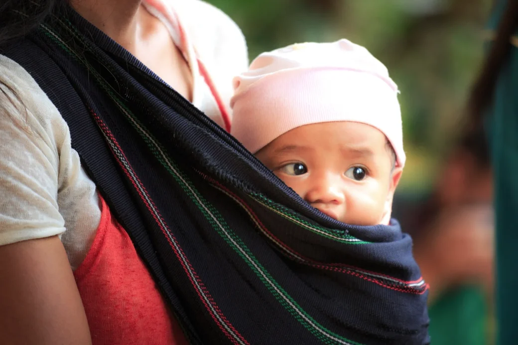 A child snuggling against the mother's chest
